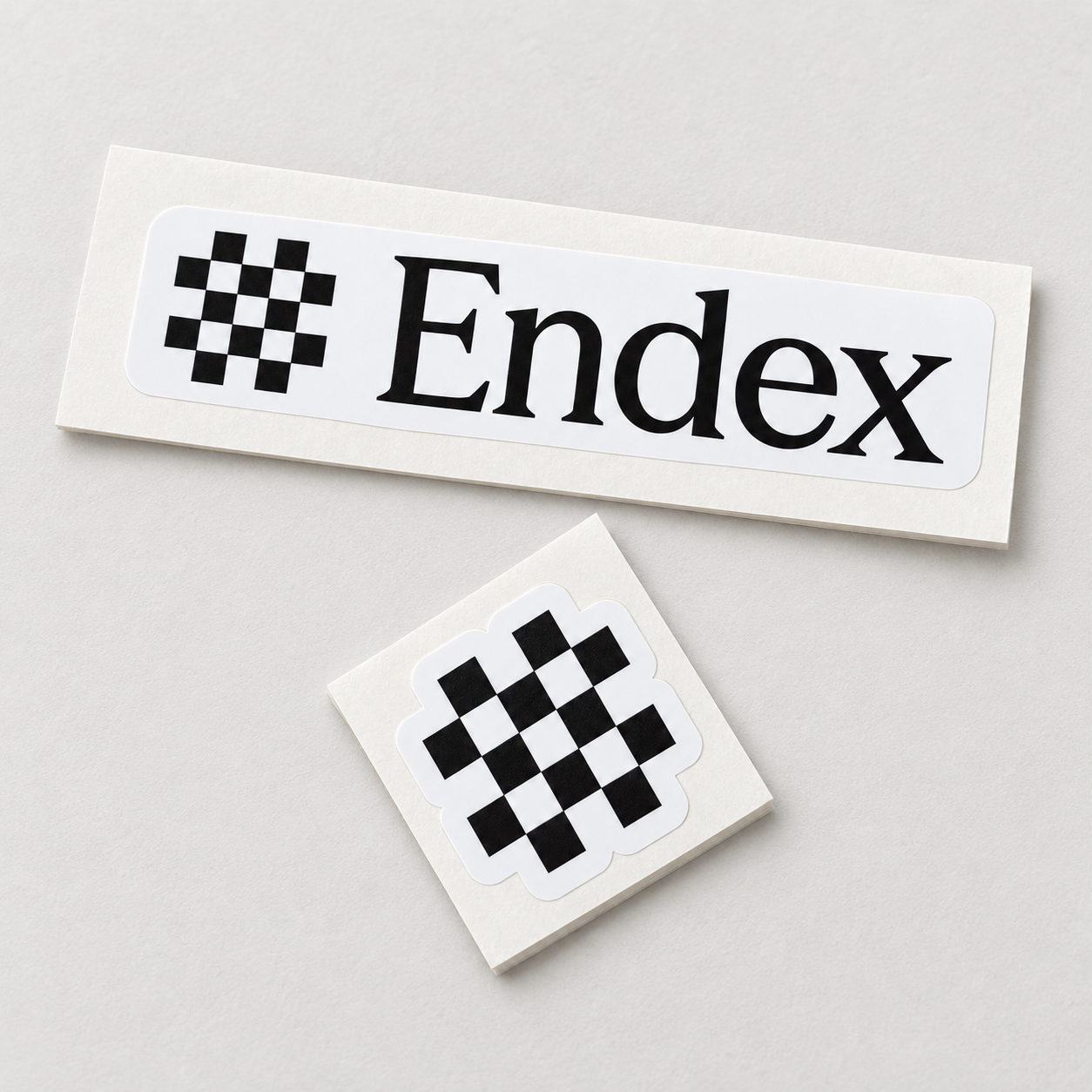 Endex wordmark and checkerboard logo stickers on a light surface