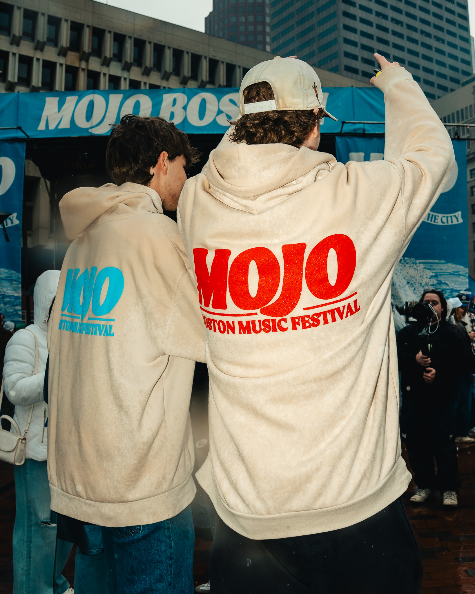 Festivalgoers wearing cream MOJO hoodies with red and blue prints
