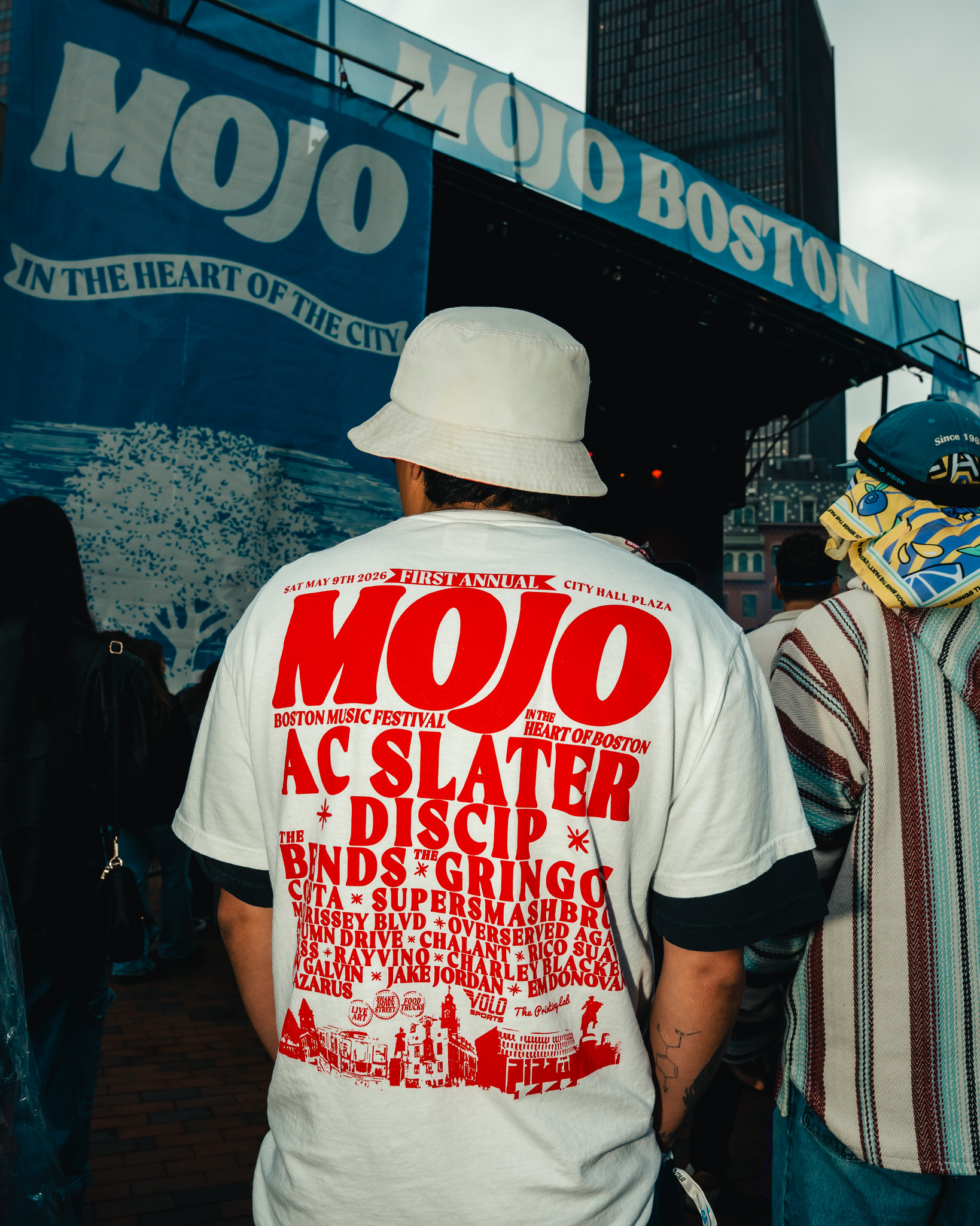 MOJO Boston festival attendee wearing a white shirt with red festival artwork