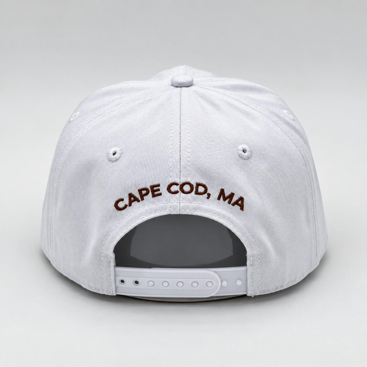 CAPE COD, MA embroidery above the adjustable snap closure.