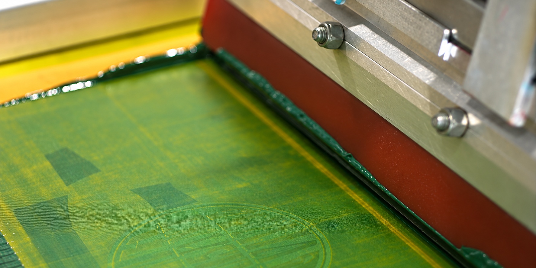 Close-up of a screen-printing press and ink screen