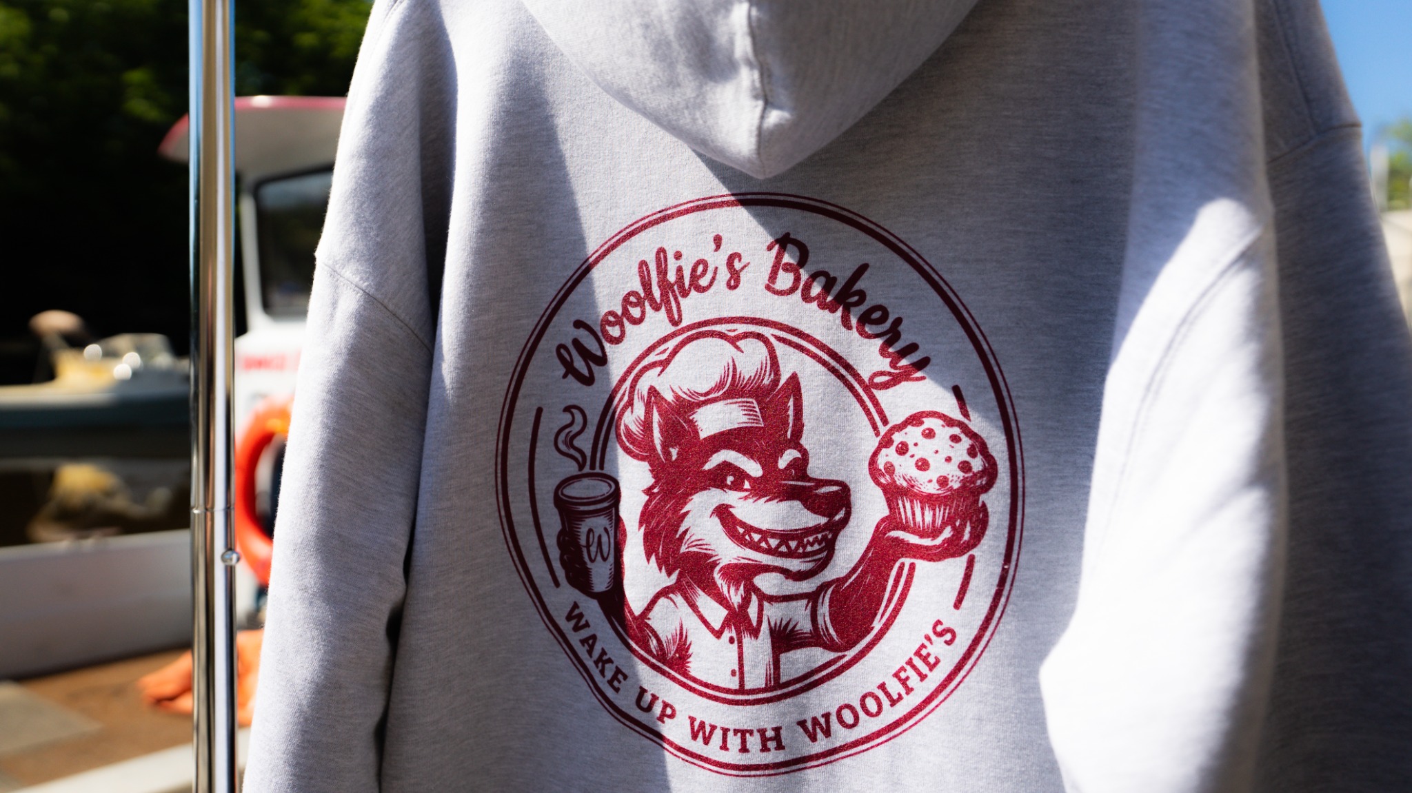 Gray hoodie with burgundy Woolfies Bakery wolf and muffin artwork